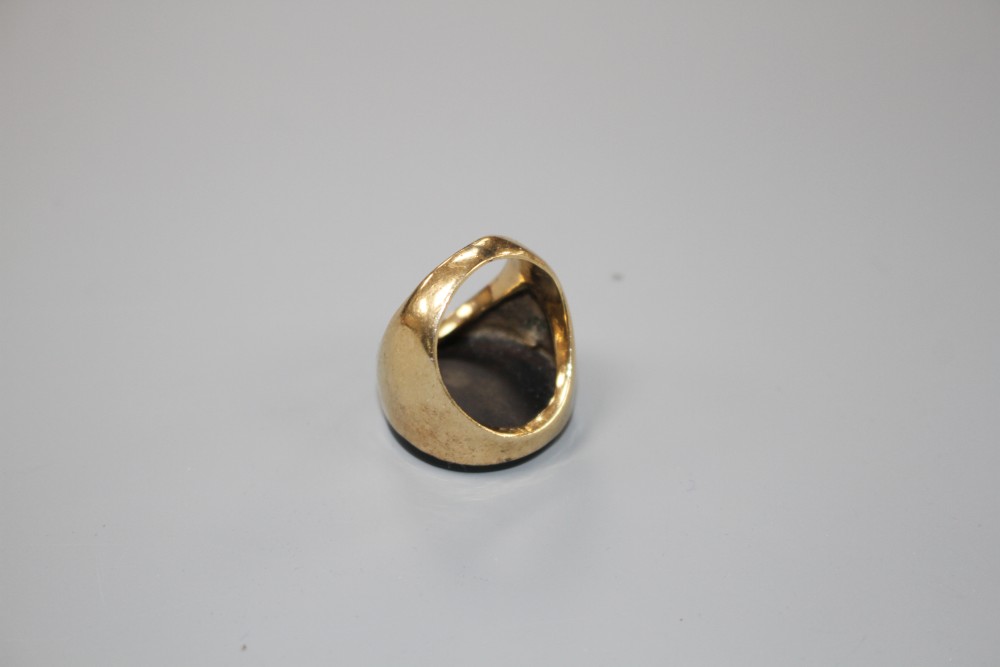 A yellow metal (stamped 9ct) and black onyx set circular signet ring, size L, gross weight 9 grams.